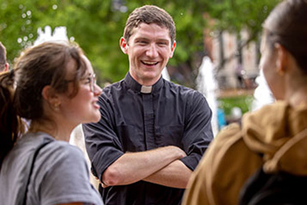 Two students speaking with a member of the ministry