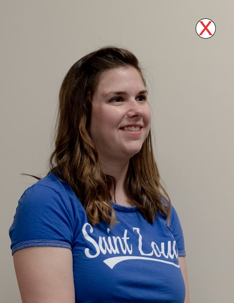 Example of bad position  headshot of a woman wearing a SLU t-shirt. Her head and body are angled to the right and away from the camera.
