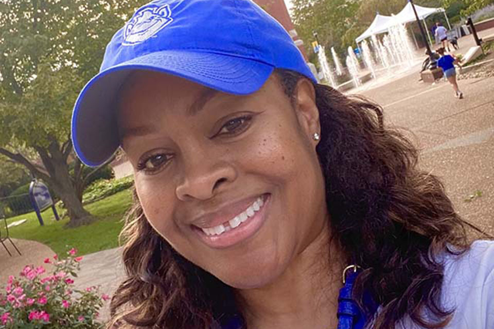 Lydia Pye Huston poses for a photo on campus with the clocktower behind her.