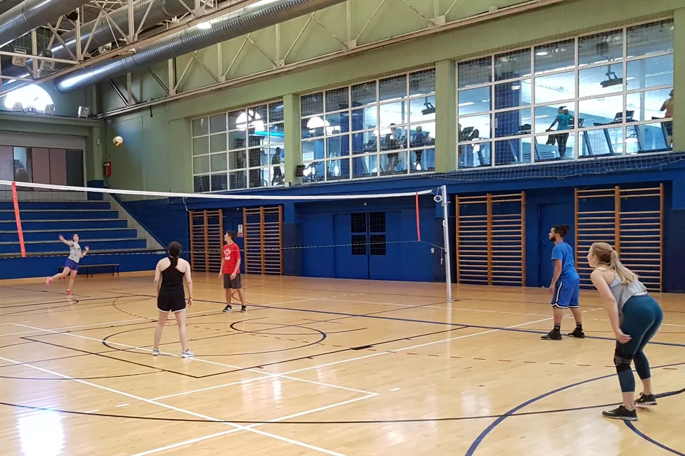 Some players practice volleyball in a sports complex.