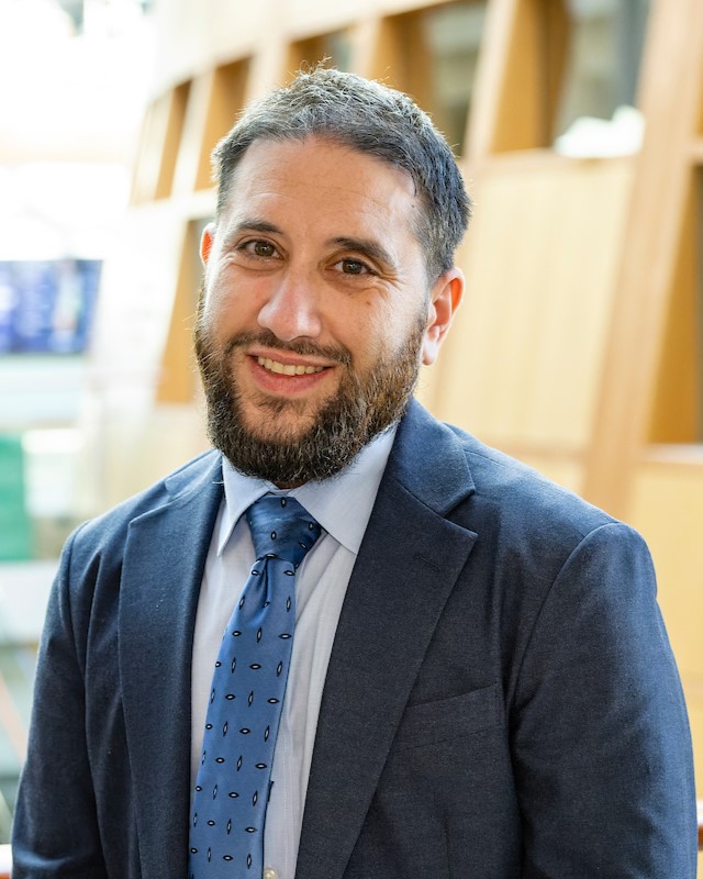 Al Miner Headshot of Al Miner wearing a light blue dress shirt, cornflower blue tie, and slate blue suitcoat