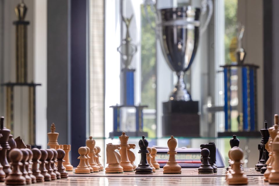A chess board at SLU surrounded by trophies.