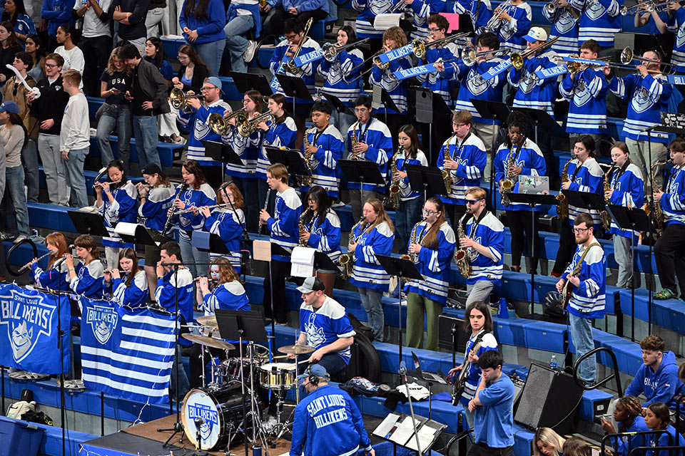 The Billiken Pep Band, featuring dozens of musicians in blue-and-white Billiken hockey jerseys, plays at Chaifetz Arena.